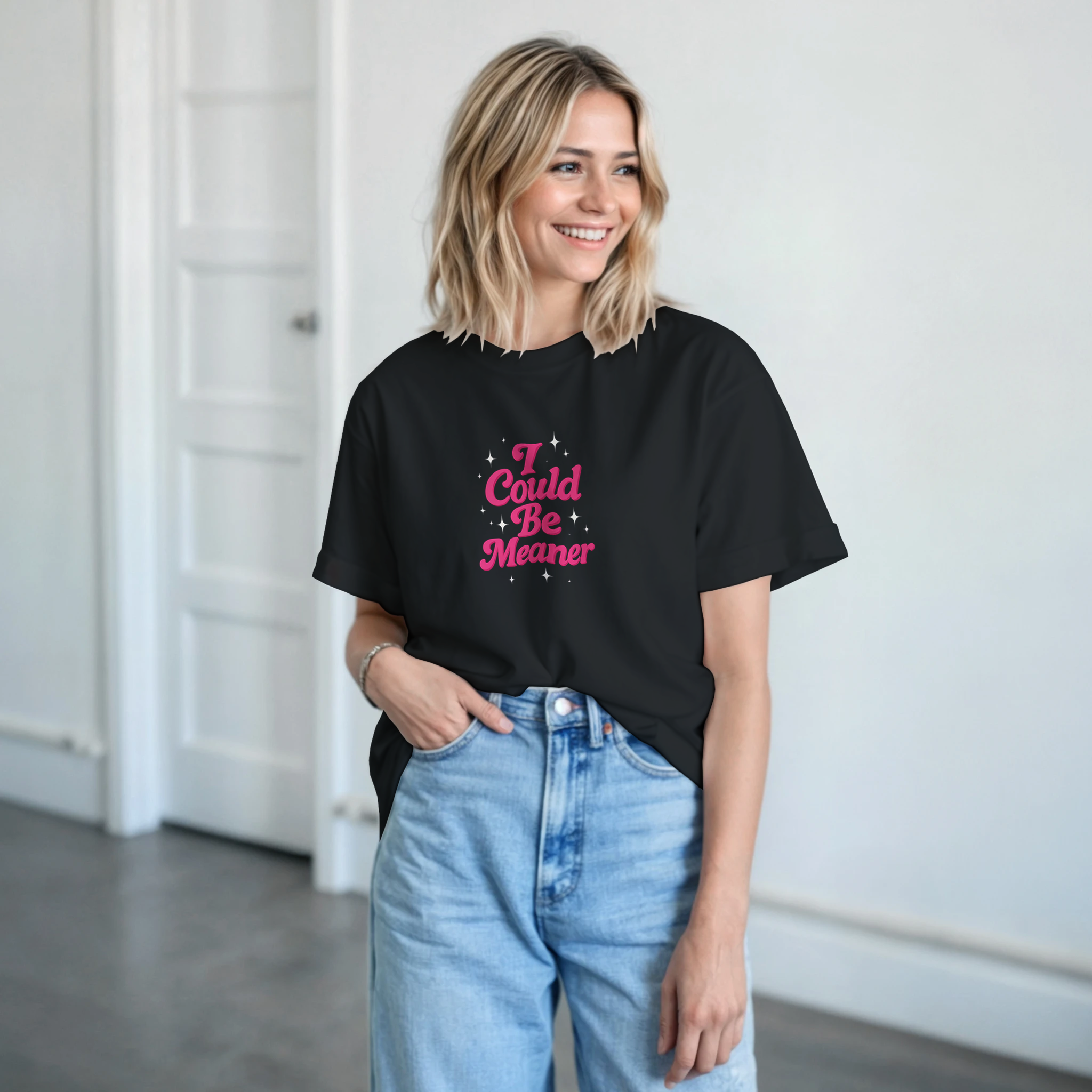 Woman wearing a black t-shirt with pink text in a minimal indoor setting